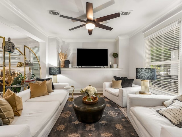 living area featuring visible vents, ornamental molding, ceiling fan, and wood finished floors