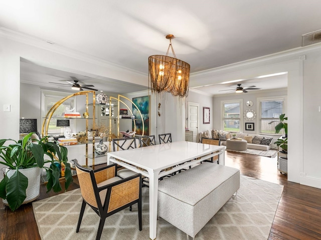 dining room featuring wood finished floors, ornamental molding, ceiling fan, and visible vents