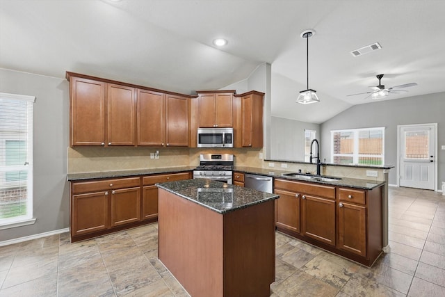 kitchen featuring appliances with stainless steel finishes, a sink, a peninsula, lofted ceiling, and visible vents