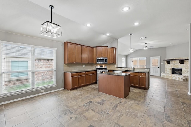 kitchen with appliances with stainless steel finishes, a sink, open floor plan, vaulted ceiling, and visible vents