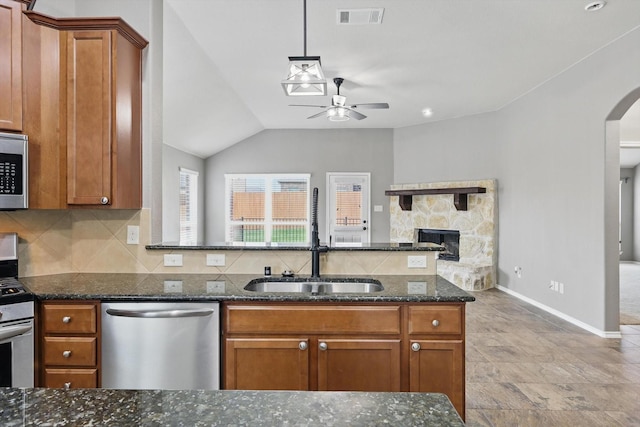 kitchen with visible vents, a ceiling fan, brown cabinets, arched walkways, and appliances with stainless steel finishes
