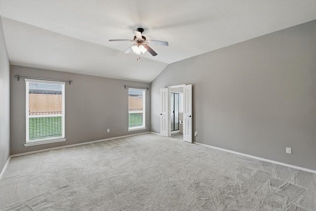 unfurnished bedroom with baseboards, a ceiling fan, carpet, and vaulted ceiling