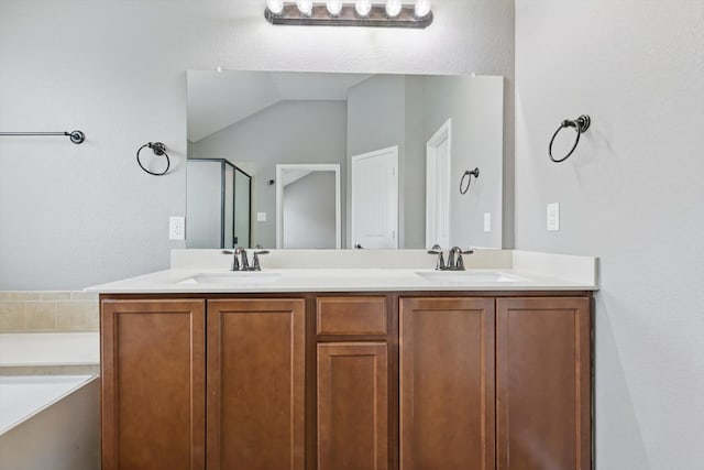 bathroom featuring a sink, a shower stall, and double vanity