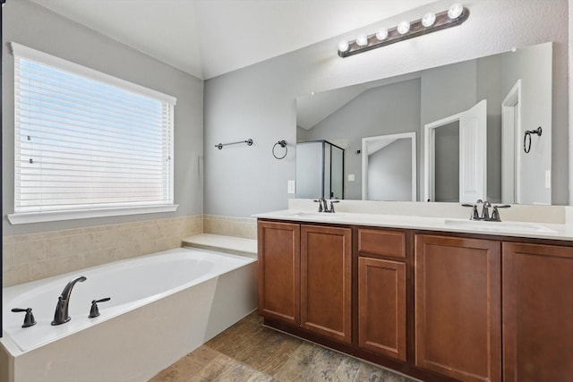 full bath with double vanity, a sink, a garden tub, and a stall shower