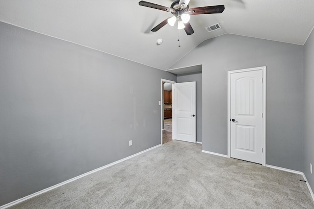 unfurnished bedroom with visible vents, lofted ceiling, baseboards, ceiling fan, and carpet