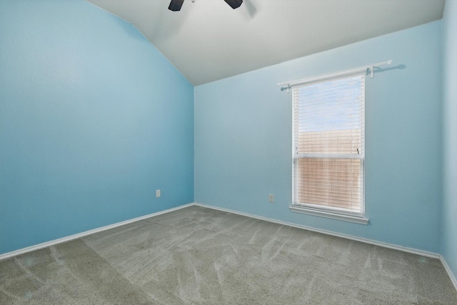 unfurnished room with plenty of natural light, ceiling fan, carpet, and vaulted ceiling