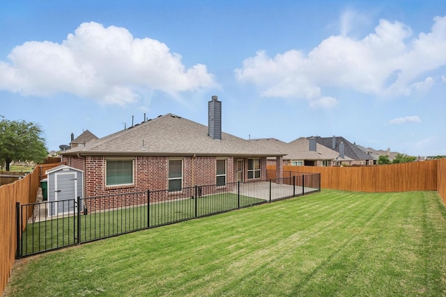 rear view of property with brick siding, a fenced backyard, a yard, and a storage unit