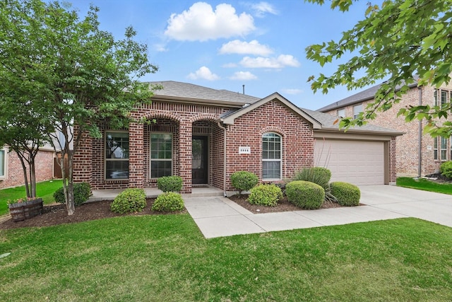 view of front of property with an attached garage, concrete driveway, a front yard, and brick siding