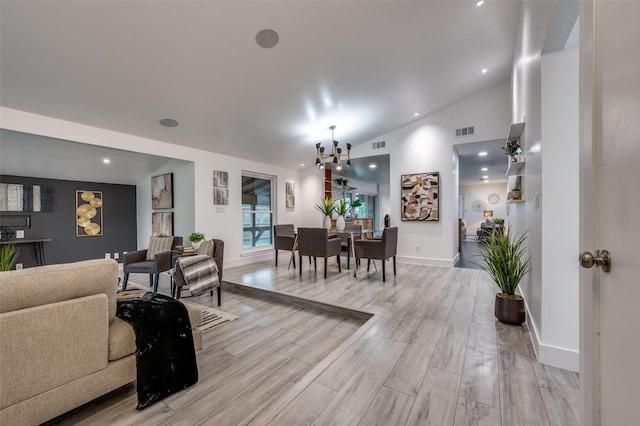 living area featuring baseboards, visible vents, an inviting chandelier, and light wood finished floors