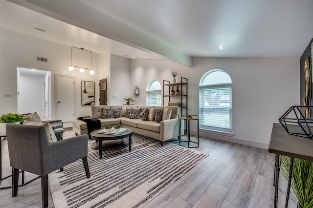 living area featuring light wood-style flooring, recessed lighting, baseboards, beamed ceiling, and visible vents