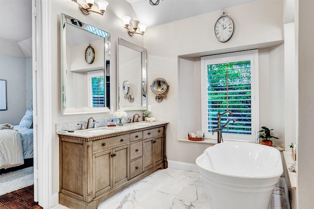 bathroom with double vanity, a soaking tub, a sink, and ensuite bath