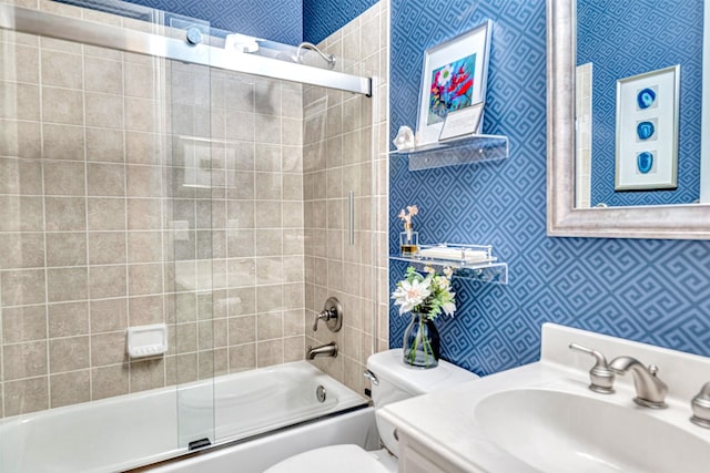 full bath featuring toilet, wallpapered walls, bath / shower combo with glass door, and vanity