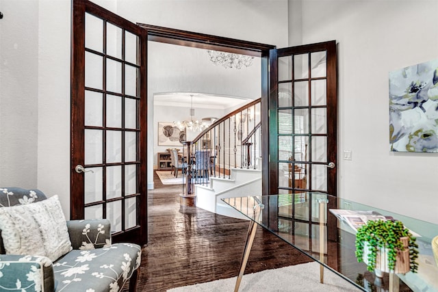 interior space with a chandelier, ornamental molding, wood finished floors, and stairway