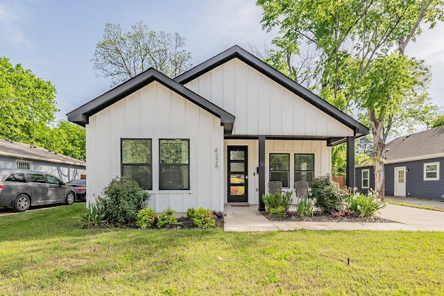 view of front of home featuring a porch, a front lawn, and board and batten siding