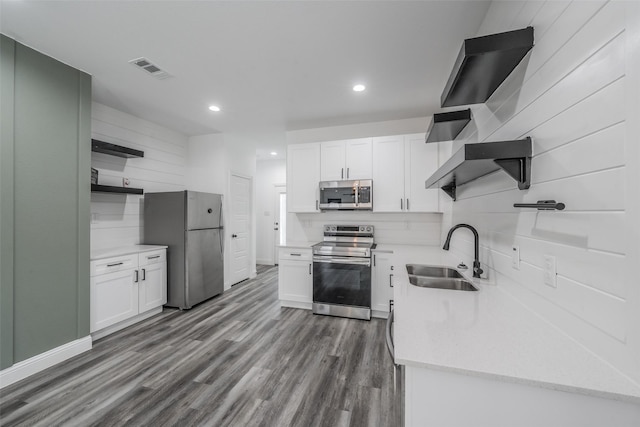 kitchen featuring open shelves, a sink, stainless steel appliances, white cabinetry, and backsplash