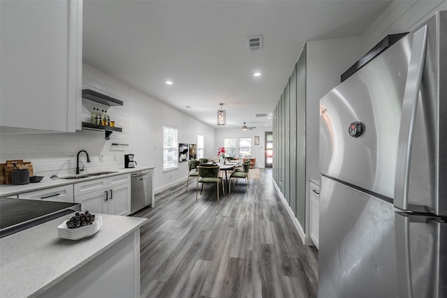 kitchen with dark wood-style flooring, open shelves, a sink, stainless steel appliances, and visible vents