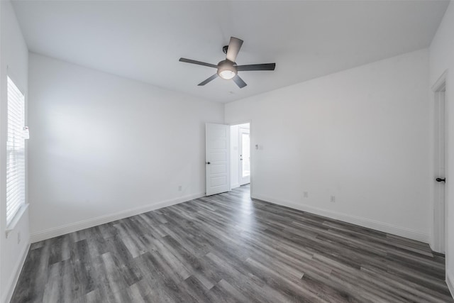 empty room with a ceiling fan, baseboards, and dark wood-style floors
