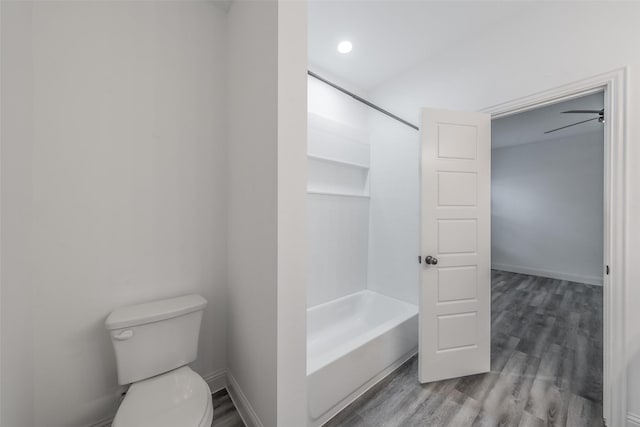full bath featuring shower / tub combination, baseboards, wood finished floors, and toilet
