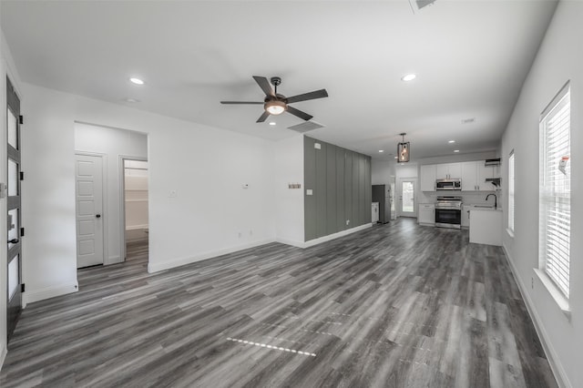 unfurnished living room with recessed lighting, a ceiling fan, dark wood finished floors, and baseboards