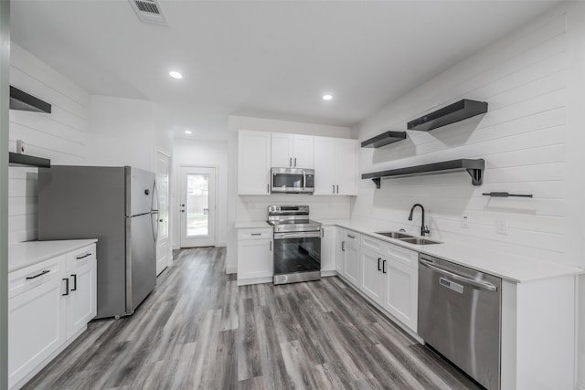kitchen with open shelves, appliances with stainless steel finishes, a sink, white cabinetry, and visible vents