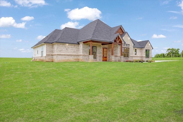 french country home with roof with shingles, a front lawn, and brick siding