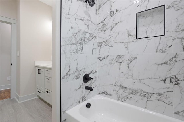 full bathroom with vanity, baseboards, and shower / tub combination