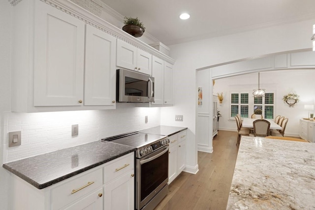 805 S Lindsay St, Gainesville, TX 76240 - kitchen featuring appliances with stainless steel finishes, white cabinets, backsplash, dark stone counters, and recessed lighting