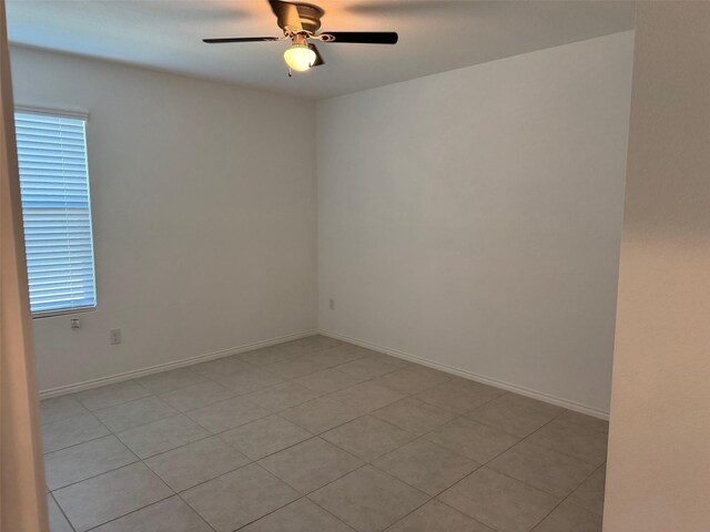 spare room with a ceiling fan, baseboards, and light tile patterned flooring