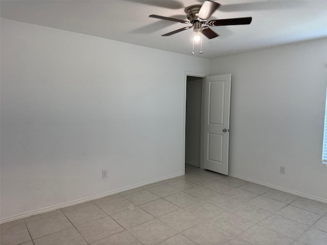 spare room featuring baseboards and a ceiling fan