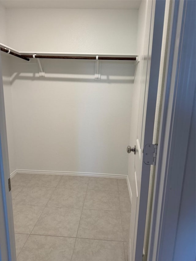 spacious closet with light tile patterned floors