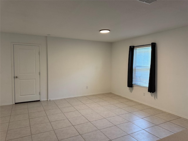 empty room with baseboards and light tile patterned floors