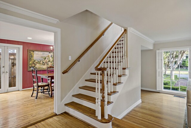 stairs featuring french doors, visible vents, crown molding, wood finished floors, and baseboards