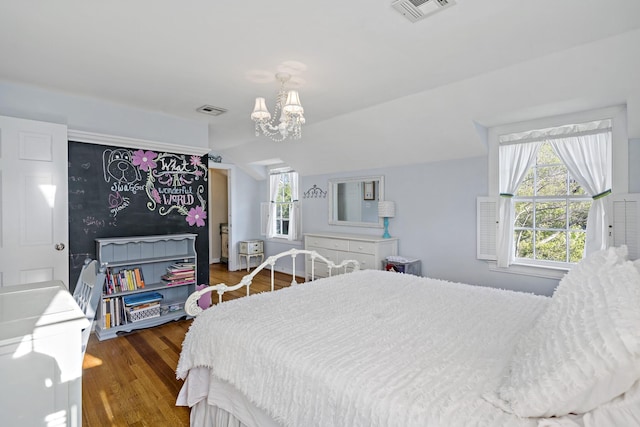bedroom with a notable chandelier, visible vents, wood finished floors, and lofted ceiling