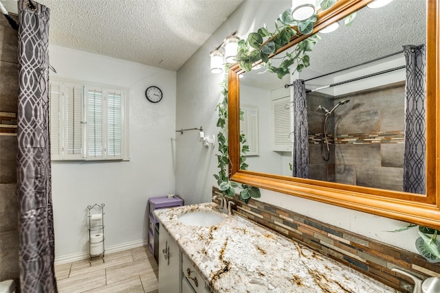 1813 Brook Hollow Dr, Fort Worth, TX 76114 - bathroom with a textured ceiling, tile patterned flooring, baseboards, vanity, and tiled shower