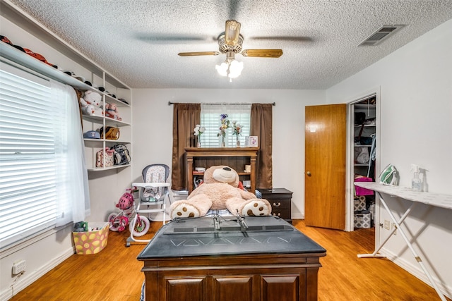 1813 Brook Hollow Dr, Fort Worth, TX 76114 - bedroom featuring a textured ceiling, a ceiling fan, light wood-style flooring, and visible vents