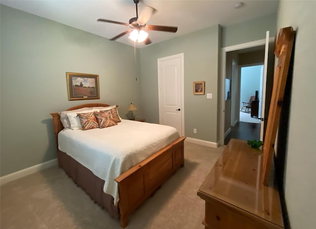 bedroom featuring baseboards, ceiling fan, and light carpet