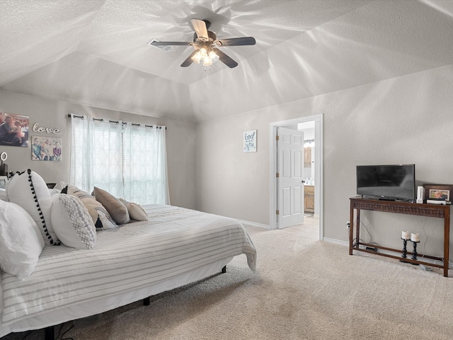 carpeted bedroom featuring lofted ceiling, baseboards, ceiling fan, a textured ceiling, and ensuite bath
