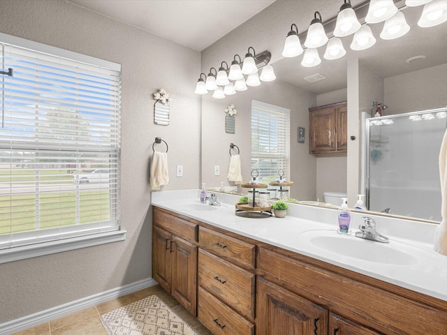 full bathroom featuring baseboards, a sink, toilet, and a shower stall