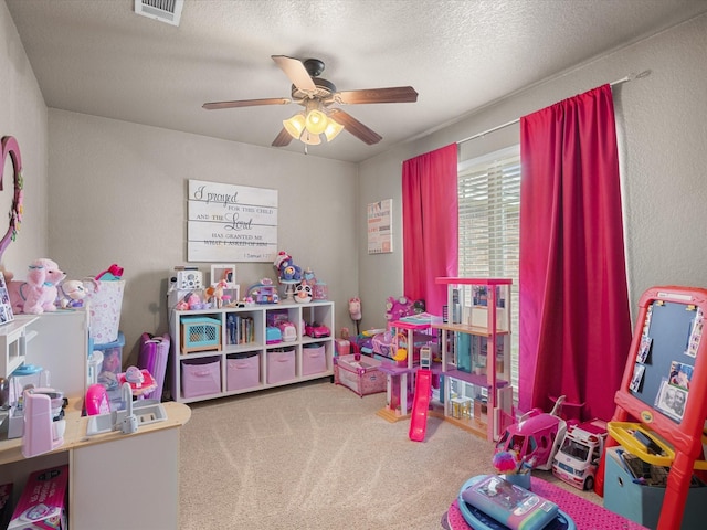 recreation room with visible vents, a textured ceiling, ceiling fan, and carpet floors
