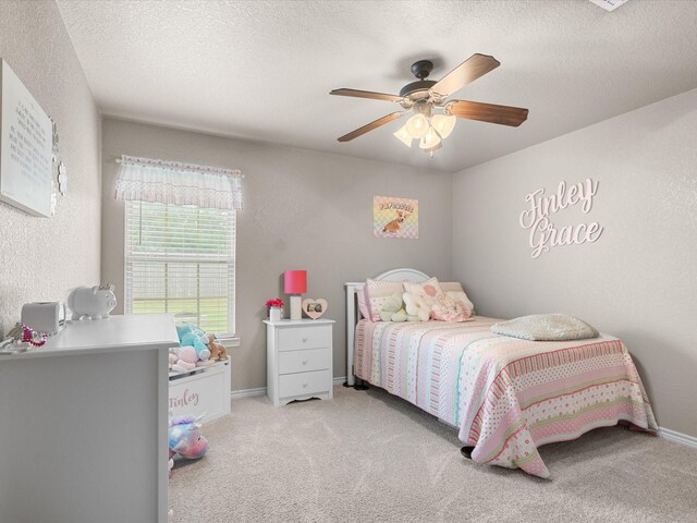 carpeted bedroom with baseboards, a ceiling fan, and a textured ceiling