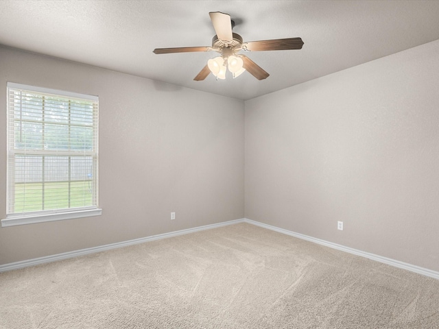 empty room with baseboards, ceiling fan, and carpet
