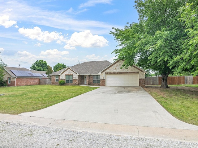 ranch-style house featuring a garage, a front lawn, fence, brick siding, and concrete driveway