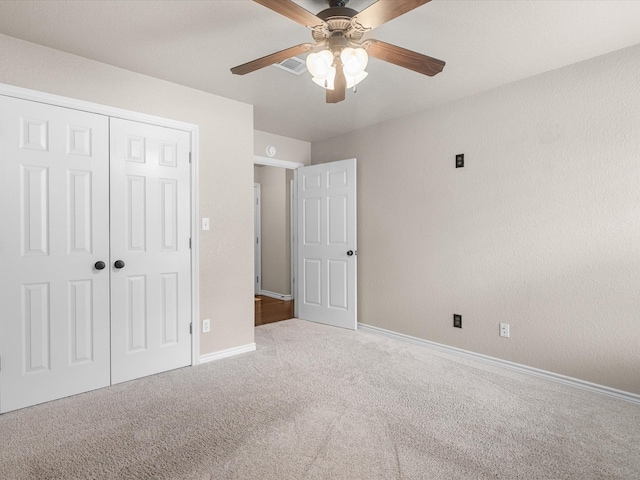 unfurnished bedroom featuring a ceiling fan, baseboards, carpet, and a closet