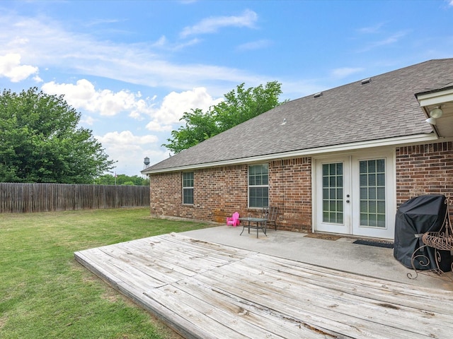 deck featuring a lawn, a fenced backyard, and french doors