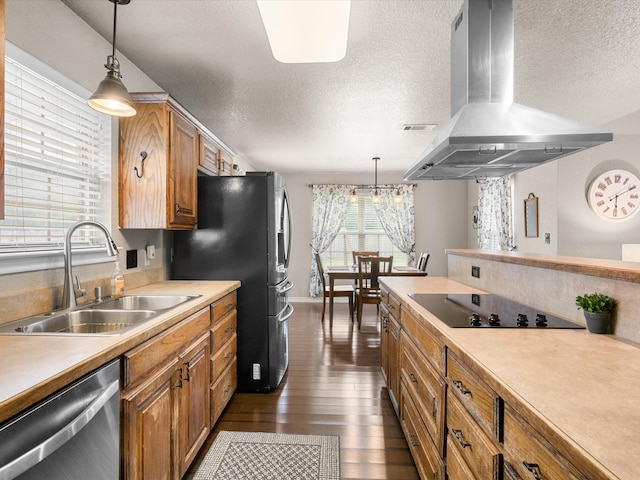 kitchen with light countertops, ventilation hood, a textured ceiling, a sink, and stainless steel appliances