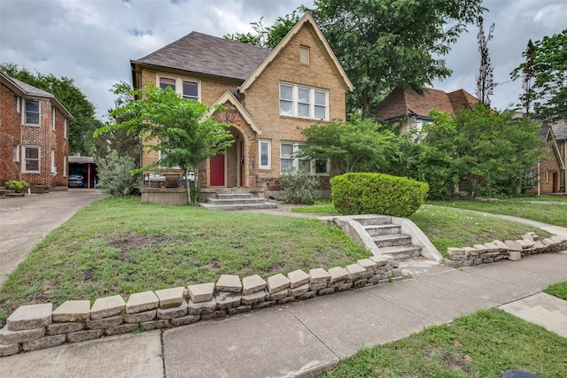 tudor house with brick siding and a front yard