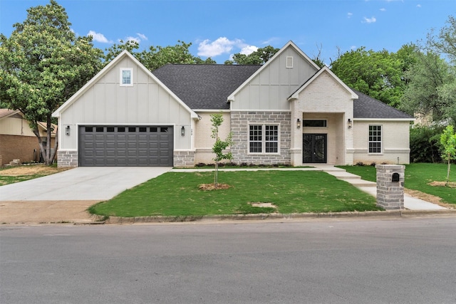 view of front facade featuring a shingled roof, a front lawn, brick siding, board and batten siding, and driveway
