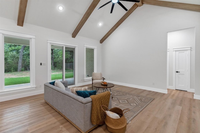 living area with baseboards, ceiling fan, beam ceiling, and light wood-type flooring