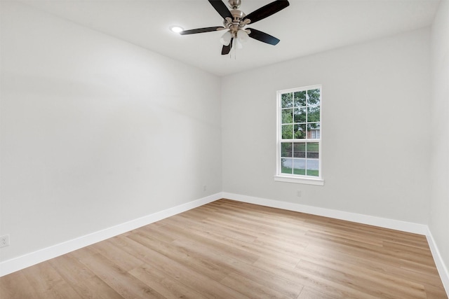 unfurnished room with baseboards, ceiling fan, and light wood-style flooring