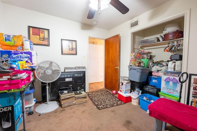 recreation room with carpet floors, ceiling fan, and visible vents